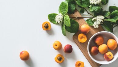 A bright still life of fresh apricots and blossoms on a cutting board, perfect for healthy eating.