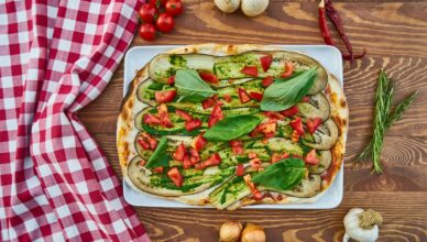 Delicious vegetable pizza with fresh basil, tomatoes, and eggplant, perfect for a healthy meal.