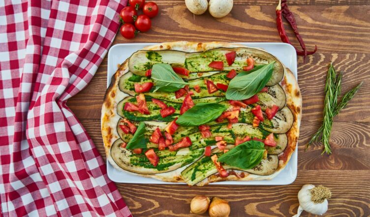 Delicious vegetable pizza with fresh basil, tomatoes, and eggplant, perfect for a healthy meal.