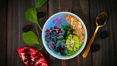 mixed fruits on bowl with blueberry on top