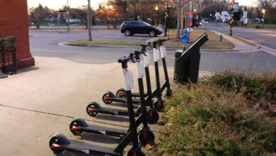a row of scooters parked on the side of a road