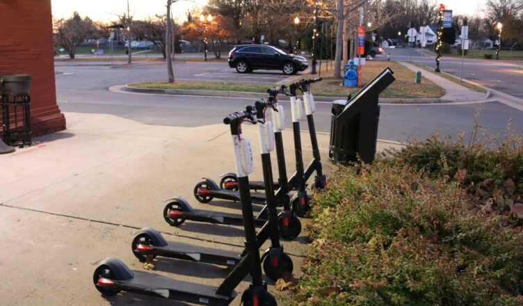 a row of scooters parked on the side of a road