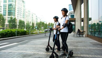 two women riding kick scooters