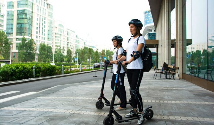 two women riding kick scooters